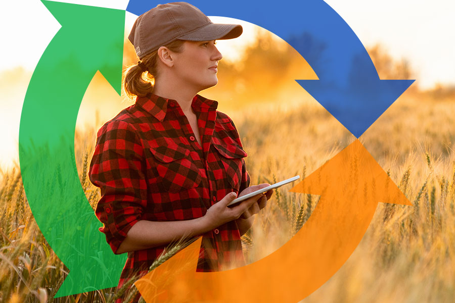 Woman stands in a wheat field using a tablet with conexon logo behind.