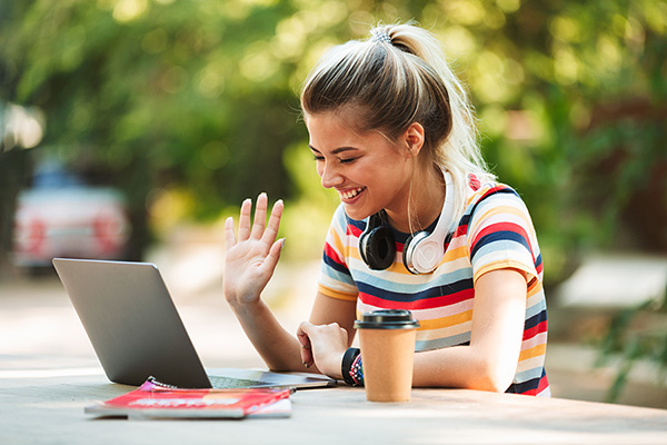 A woman outside using her computer connected to wireless fiber internet.